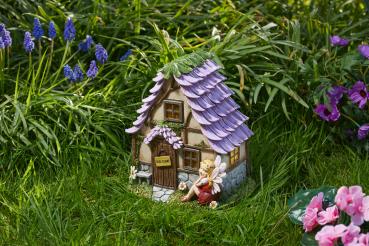 Preview: Solar-Feenhaus in Form einer kleinen Waldhütte im Garten stehend, unbeleuchtet.